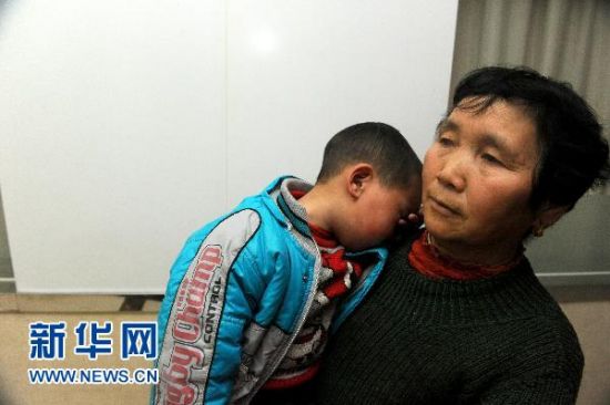 1月5日，在安徽省立儿童医院，安徽省安庆市怀宁县高河镇一名家长抱着孩子。新华社记者 郭晨 摄