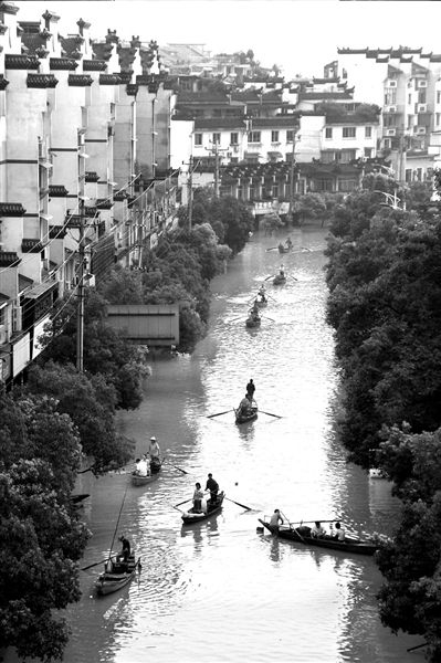 6月20日,浙江兰溪市区一低洼地带道路被水淹没,市民只能乘船出行。新华社发 6月20日,浙江兰溪市区一低洼地带道路被水淹没,市民只能乘船出行。新华社发