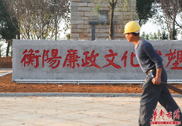 一名工人正从衡阳廉政文化雕塑园前经过.jpg