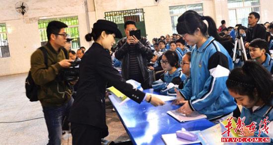 图为民警在为学生发放宣传资料.JPG