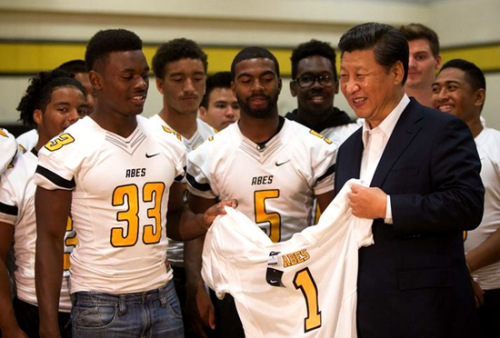 习近平参观美国塔科马市林肯中学时，学校橄榄球队将球衣和球赠给习近平。图片来源：中国网
