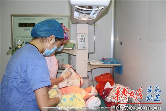 医护人员为刚出生的婴儿细心穿好衣服.JPG