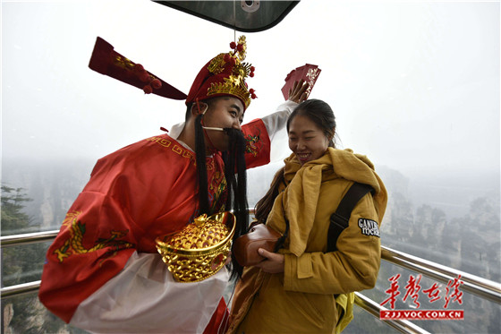 2月6日，张家界百龙天梯一名工作人员装扮成财神向游客送红包。向韬摄.jpg