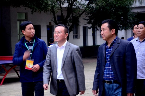 杨胜跃在查看校园过程中听过斌汇报工作.jpg